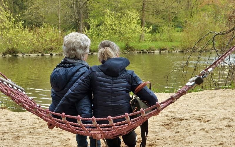 Auf dem Bild sieht man zwei Frauen, die unterstützend zusammensitzen