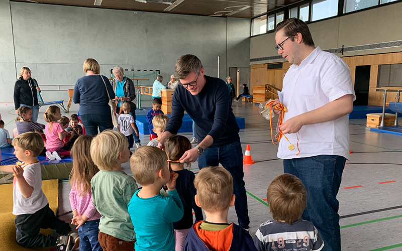 Kinder bekommen eine Medaille überreicht